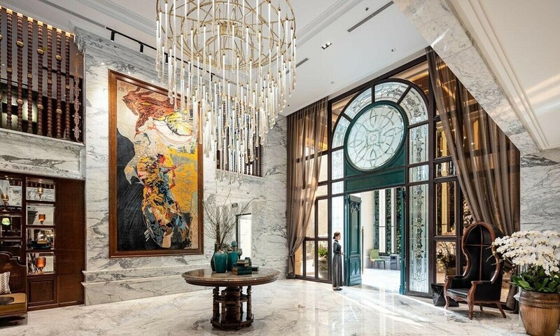 Peridot Grand Luxury Boutique Hotel - Viên Ngọc Quý Phái Giữa Lòng Thủ Đô Giữa lòng thủ đô cổ kính, Peridot Grand Luxury Boutique Hotel như một viên ngọc với vẻ đẹp tiềm ẩn cùng nhiều câu chuyện thú vị chờ đợi du khách đến khám phá. Khách sạn này có điều gì đặc biệt? Cùng theo chân Tico Travel khám phá chi tiết ngay sau đây nhé! 1. Giới thiệu đôi nét về Peridot Grand Luxury Boutique Hotel ẢNH 1 Peridot Grand Luxury Boutique Hotel là một khách sạn chuẩn 5 sao quốc tế nằm ngay tại khu phố cổ - trái tim của thủ đô Hà Nội. Khách sạn bắt đầu mở cửa đón khách từ giữa năm 2022 và nhanh chóng tạo được tiếng vang trong lĩnh vực lưu trú. Trước đây, khách sạn này được biết đến rộng rãi với tên gọi Peridot Grand Hotel & Spa, sau đó được đổi tên như hiện nay. Hiện nay, khách sạn Peridot Grand sở hữu tổng cộng 105 phòng nghỉ đẳng cấp với 9 hạng phòng từ cơ bản cho đến cao cấp. Bên cạnh đó là hệ thống dịch vụ và tiện ích đẳng cấp quốc tế được khách sạn đầu tư khủng hướng đến trải nghiệm hoàn hảo, giàu cảm xúc cho khách hàng. Đội ngũ quản lý, nhân viên của khách sạn Peridot mến khách, thân thiện, chuyên nghiệp và thực sự chu đáo, sẵn sàng phục vụ những nhu cầu khắt khe của khách hàng. Bằng hệ thống phòng ốc, dịch vụ hoàn hảo cộng với sự tận tâm của nhân viên, Peridot Grand Hotel chính là điểm đến lý tưởng cho bạn. 2. Vị trí và hướng dẫn di chuyển đến khách sạn Peridot Grand Hotel & Spa 2.1. Vị trí Địa chỉ: 33 Đường Thành, quận Hoàn Kiếm, Hà Nội Khách sạn Peridot Grand Luxury Boutique Hotel tọa lạc tại số 33 Đường Thành, quận Hoàn Kiếm, cách Sân bay Nội bài khoảng 28km. Với vị trí đắc địa ngay trong khu phố cổ “tấc đất tấc vàng”, du khách lưu trú tại đây có dịp trải nghiệm nét văn hóa truyền thống và nhịp sống của người dân thủ đô. Peridot Grand Luxury Boutique Hotel nằm gần các điểm đến nổi tiếng của Hà Nội như Hồ Hoàn Kiếm, Lăng Bác, Phố cổ, Phố đi bộ Hồ Gươm,... Xung quanh khách sạn 5 sao là nhiều nhà hàng, quán ăn, khu mua sắm sầm uất rất tiện để du khách khám phá. 2.2. Hướng dẫn di chuyển ẢNH 2 Muốn đến Peridot Grand Luxury Boutique Hotel bạn có thể lựa chọn nhiều phương án di chuyển khác nhau. Với du khách quốc tế hoặc khách đến từ các địa phương phía Nam như Đà Nẵng, Nha Trang, TP. HCM thì tiện nhất là đi bằng máy bay. Sau khi đáp xuống Sân bay quốc tế Nội Bài, bạn có thể liên hệ ngay có bộ phận lễ tân của khách sạn để sử dụng dịch vụ đón tiễn sân bay. Ngoài ra để tiết kiệm thời gian bạn cũng có thể chọn đi taxi, xe buýt hoặc xe trung chuyển. Một số hãng taxi uy tín bạn có thể tham khảo như Melinh, Vinasun hay Grab Taxi. Quang đường từ sân bay Nội Bài về khách sạn Peridot Grand mất khoảng 28km Thời gian di chuyển cho quãng đường này khoảng hơn 30 phút. Giá taxi dao động từ 300.000 - 350.000 VNĐ/chuyến 4 chỗ hoặc 7 chỗ. 3. Không gian và thiết kế kiến trúc của Peridot Grand Luxury Boutique Hotel ẢNH 3 Một trong lý do Peridot Grand Luxury Boutique Hotel nhận được sự yêu thích của khách lưu trú chính là không gian nghỉ dưỡng sang trọng, riêng tư cùng lối thiết kế kiến trúc độc đáo. Tọa lạc ngay trong khu phố cổ sầm uất nhưng không gian bên trong của khách sạn lại bình yên và riêng tư đến lạ, hoàn toàn biệt lập với sự huyên náo, xô bồ của khu phố. Không chạy theo các xu hướng đang thịnh hành, Peridot Grand Hotel & Spa trung thành với những giá trị riêng biệt, mang nét đặc sắc và thanh lịch của thủ đô ngàn năm văn hiến. Phong cách kiến trúc tiêu biểu của Peridot là Indochine kết hợp với mét lãng mạn của kiến trúc Pháp, điểm tô họa tiết Á Đông tạo nên sự trang nhã, quý phái. ẢNH 4 Mỗi góc của khách sạn đều được decor tinh tế với nhiều tác phẩm nghệ thuật được sắp đặt ấn tượng khơi gợi nguồn cảm hứng cho bất cứ ai có niềm đam mê với cái đẹp. Nơi đây có vô vàn góc sống ảo cực chất để bạn thỏa sức check -in sống ảo trong suốt quá trình nghỉ dưỡng. 4. Khám phá hệ thống phòng nghỉ tại Peridot Grand Luxury Boutique Hotel 4.1. Phòng Chic Deluxe ẢNH 5 Nằm tại tầng 2 của Peridot Grand Luxury Boutique Hotel, Phòng Chic Deluxe là hạng phòng cơ bản với diện tích 28m2 với tầm nhìn ra thác nước nội khu và góc phố lân cận. Căn phòng nhỏ xinh nhưng rất sang trọng với vẻ đẹp đương đại thu hút mọi ánh nhìn. Trong phòng có đặt 1 giường đôi hoặc 2 giường twin cho 2 khách người lớn. Mặt khác, phòng Chic Deluxe còn có khu vực nhà tắm riêng tư với vies thác nước tuyệt đẹp có cả vòi hoa sen và bồn tắm riêng biệt. 4.2. Phòng Premier Deluxe ẢNH 6 Phòng Premier Deluxe của Peridot Grand Luxury Boutique Hotel rộng từ 28 - 32m2, mở ra một không gian yên tĩnh và thư thái cho khách lưu trú. Điểm nhấn của căn phòng này là tone màu xanh lam quý phái. Tất cả các phòng Premier Deluxe đều có view phố tuyệt đẹp, bên trong bố trí 1 giường King hoặc 2 giường đôi. Phòng tắm thanh lịch, sạch sẽ có vòi tắm đứng, bồn tắm nằm hoặc vòi hoa sen riêng biệt. 4.3. Phòng Grand Deluxe ẢNH 7 Sở hữu nhiều nét tương đồng với Premier Deluxe, Grand Deluxe rộng 28 - 32m2 là sự lựa chọn hoàn hảo cho các cặp đôi hoặc nhóm khách 2 người. Phòng khá rộng với view phố cổ đẹp mê ly. Nội thất là hàng cao cấp, các tiện nghi được tích hợp đầy đủ để bạn tận hưởng kỳ nghỉ thư thái. 4.4. Phòng Junior Suite ẢNH 8 Yên tĩnh và thoáng đãng là những du khách có thể cảm nhận về hạng phòng Junior Suite của Peridot Grand Luxury Boutique Hotel. Căn phòng rộng 30m2 bố trí một giường King cỡ lớn. Điểm nhấn là phần cửa sổ kịch sàn với tầm view hướng thẳng ra phố cổ sầm uất. Phòng tắm có cả cabin tắm đứng vòi hoa sen và bồn tắm nằm riêng để bạn thư giãn sau một ngày dài hoạt động. 4.5. Phòng Luxury Suite ẢNH 9 Phòng Luxury Suite là một trong những hạng phòng sang chảnh và rộng nhất của Peridot Grand Hotel & Spa. Căn hộ này có diện tích lên tới 52m2, bố trí giường King size lớn phù hợp cho gia đình 2 người lớn kèm 1 trẻ em. Bên trong phòng có khu vực tiếp khách, làm việc setup nội thất cao cấp và nhiều tiện nghi chuẩn 5 sao để bạn và người thân trải nghiệm. Khu vực phòng tắm và vệ sinh riêng biệt, sạch sẽ và thông thoáng. Điểm nhấn là bồn tắm nằm sang trọng cho những ai yêu thích sự riêng tư. 4.6. Phòng Grand Suite ẢNH 10 Sở hữu diện tích 54m2 với thiết kế như một căn hộ nhỏ, Grand Suite được nhiều du khách lựa chọn khi đến với Peridot Grand Luxury Boutique Hotel. Căn phòng có khu vực phòng khách, phòng ngủ và nhà tắm thiết kế riêng biệt. Tổng thể không gian của Grand Suite toát lên vẻ ấm cúng, sang chảnh từ nội thất gỗ sẫm màu, các bức tranh nghệ thuật treo tường ấn tượng khơi gợi xúc cảm yêu cái đẹp của khách hàng. Sau một ngày dài với nhiều hoạt động trải nghiệm, bạn có thể ngâm mình trong bồn tắm sang trọng để thư giãn, hồi phục tinh thần. 4.7. Phòng Grand Suite Balcony ẢNH 11 Được nhiều khách hàng ví như 1 căn studio nhỏ xinh, thanh lịch, Grand Suite Balcony được nâng cấp trải nghiệm so với Grand Suite. Hạng phòng này cũng sở hữu diện tích 54m2 với phòng khách, phòng ngủ và nhà tắm riêng tư, biệt lập nhưng có thêm góc ban công rộng rãi. Phía ngoài ban công Peridot Grand Luxury Boutique Hotel cho bố trí bàn ghế để bạn đọc sách, thưởng trà và ngắm nhìn khu phố cổ lung linh ánh đèn mỗi khi đêm về. Bên trong phòng ngủ là 1 chiếc giường đôi cỡ King cực rộn rái, êm ái để bạn có giấc ngủ sâu êm ái. Điểm nhấn trong thiết kế căn hộ nghỉ dưỡng là gam màu xanh và cam trầm ấm tạo nên sự quý phái, trang nhã. 4.8. Phòng Premier Connecting Room ẢNH 12 Premier Connecting Room của khách sạn Peridot Grand Hotel là sự lựa chọn lý tưởng cho các gia đình với sức chứa tối đa 4 khách người lớn kèm 1 trẻ em. Hạng phòng này là sự kết hợp 2 phòng Premier Deluxe tổng diện tích 56m2. Phòng ngủ setup 1 giường King và 2 giường đơn. Bên cạnh đó là không gian tiếp khách, sinh hoạt chung cho các thành viên và nhà tắm riêng tư có cả vòi hoa sen và bồn tắm nằm rộng rãi. 4.9. Phòng Grand Connecting Room ẢNH 13 Grand Connecting Room của Peridot Grand Luxury Boutique Hotel hoàn toàn phù hợp cho những gia đình gồm 4 khách người lớn và 1 khách trẻ em. Căn phòng là sự kết nối 2 phòng Grand Deluxe với diện tích 56m2 khá rộng rãi cùng view phố cổ nên thơ. Hạng phòng này có bố trí 1 giường King lớn và 2 giường Twin với chăm ga gối nệm hàng cao cấp để bạn có giấc ngủ ngon. Lựa chọn Grand Connecting Room, bạn sẽ được trải nghiệm những dịch vụ và tiện ích cao cấp nhất của khách sạn. 5. Dịch vụ và tiện ích nổi bật tại khách sạn Peridot Grand Hotel & Spa 5.1. Ẩm thực Nhà hàng 1968 ẢNH 14 Tọa lạc tại tầng hầm B1 của khách sạn Peridot Grand, nhà hàng 1968 mang đến cho thực khách những trải nghiệm ẩm thực Việt Nam và châu Á đặc sắc. Du khách đến nhà hàng có thể thỏa sức chọn cho mình các món ăn truyền thống Việt Nam, Nhật Bản, Trung Quốc hay Hàn Quốc trong không gian decor thanh lịch, duyên dáng. Đặc biệt ở đây còn có cả khu vực phòng riêng phù hợp cho các bữa tiệc thân mật. Nhà hàng Olivine ẢNH 15 Nhà hàng Olivine nằm tại tầng 11 của Peridot Grand Luxury Boutique Hotel. Nơi đây là địa chỉ tin cậy cho những ai là tín đồ của đồ u. Khu nhà hàng thiết kế thoáng đãng với tầm nhìn thơ mộng ra khu bể bơi ngoài trời. Bạn có thể thỏa sức thưởng thức các món ăn ngon trong khung cảnh thơ mộng. Ở đâu cũng có phòng riêng với sức chứa từ 10 - 12 khách cho những ai có nhu cầu. Khung giờ hoạt động của nhà hàng Olivine là từ 11:00 – 21:45 hàng ngày kể cả ngày Lễ, Tết. Ignite Sky Bar ẢNH 16 Ignite Sky Bar tọa lạc trên tầng thượng của khách sạn Peridot Grand Hotel với tầm nhìn 360 độ ra khu phố cổ. Địa điểm này được mệnh danh là rooftop bar đẳng cấp bậc nhất khu vực nội ô của thủ đô. Bar có thiết kế mở, không gian thoáng đãng, thiết kế theo phong cách nhã nhặn, thanh lịch tạo thiện cảm cho thực khách khi đến đây. Sức chứa tối đa của Ignite Sky Bar là 350 khách đối với tiệc đứng và 180 khách với tiệc ngồi. Sảnh khách sạn ẢNH 17 Sảnh khách sạn Peridot Grand Luxury Boutique Hotel khá rộng rãi với thiết kế sang trọng tới từng tiểu tiết. Đây là nơi du khách có thể thưởng thức những bữa ăn nhẹ, nhâm nhi tách cafe hay ly cocktail được pha chế theo công thức riêng. Bên cạnh đó, thiết kế mở giúp du khách ngắm nhìn toàn cảnh thác nước nội khu cũng như lối trang trí đậm chất nghệ thuật. Bạn có thể đến sảnh khách sạn để nghỉ ngơi, thư giãn hoặc gặp gỡ bạn bè, đối tác. 5.2. Sức khỏe và làm đẹp Peridot Spa ẢNH 18 Peridot Spa mở cửa từ 9:00 – 22:00 mang đến cho khách lưu trú một thiên đường nghỉ dưỡng, thư giãn với những liệu pháp trị liệu, massage ấn tượng, hiệu quả cao có nguồn gốc từ thiên nhiên. Sau khi sử dụng dịch vụ tại Spa của Peridot Grand Luxury Boutique Hotel bạn sẽ cảm thấy cơ thể khỏe khoắn và tràn đầy sức sống. Phòng tập thể hình ẢNH 19 Hoạt động trong khung giờ từ 9:00 - 21:00 hàng ngày phòng tập thể hình tại tầng 2 của khách sạn Peridot Grand Luxury Boutique Hotel là địa chỉ để bạn duy trì vóc dáng thon gọn, cơ bắp săn chắc. Nơi đây bố trí nhiều máy móc, trang thiết bị tập luyện hiện đại, miễn phí để bạn trải nghiệm. Bể sục Jacuzzi, phòng xông khô và xông hơi ẢNH 20 Peridot Grand sở hữu đầy đủ các tiện ích bể sục Jacuzzi, phòng xông khô và xông hơi đạt chuẩn 5 sao quốc tế để du khách thoải mái thư giãn cũng như chăm sóc sức khỏe cho bản thân. Bạn có thể ngâm mình trong làn nước nóng để thư giãn, giải tỏa căng thẳng, giảm đau nhức xương khớp hay trải nghiệm xông hơi khô, xông hơi ướt để đào thải các chất độc hại ra khỏi cơ thể. Bể bơi vô cực ẢNH 21 Bể bơi vô cực của Peridot Grand Luxury Boutique Hotel nằm tại tầng thượng của khách sạn, ngay cạnh nhà hàng Olivine. Khách sạn tự hòa khi đây chính là bể bơi vô cực tầng cao duy nhất trong khu phố cổ. Từ dưới đây có thể ngắm nhìn bao quát, toàn cảnh những ngôi nhà góc phố trong nội ô quận Hoàn Kiếm. Bạn có thể đến bể bơi trong khung giờ từ 9:00 - 21:00 để bơi lội, thư giãn hay chụp hình check - in sống ảo với background đẹp ngoạn mục. 5.3. Hội nghị và Sự kiện ẢNH 22 Hiện nay Peridot Grand Luxury Boutique Hotel đang sở hữu 3 phòng hội nghị Saphire và 1 phòng tiệc lớn Grand Sapphire với không gian rộng rãi, setup nội thất liên hoạt cùng âm thanh - ánh sáng hiện đại. Nơi đây chuyên được chọn để tổ chức các bữa tiệc hay các sự kiện quan trọng như tiệc cưới, lễ ký kết hợp đồng,... 6. Review khách sạn Peridot Grand Hotel từ phía khách hàng Dưới đây là những feedback ấn tượng của khách lưu trú về khách sạn Peridot Grand mà Tico Travel đã tổng hợp và chia sẻ đến bạn: Chị Quỳnh Anh (Rate 5/5 sao) cho hay: “Nhân viên Peridot Grand Luxury Boutique Hotel siêu thân thiện, nhiệt tình hỗ trợ mọi thắc mắc của gia đình mình. Chỗ nghỉ sạch sẽ, trang nhã, vị trí thuận tiện cho việc tham quan du lịch.” Anh Hoàng Long (Rate 5/5 sao) nêu cảm nhận: “Khách sạn Peridot Grand Luxury Boutique Hotel chuẩn 5 sao quốc tế, gồm nhiều hạng phòng để lựa chọn. Phong cách kiến trúc giàu tính nghệ thuật, có nhiều góc để sống ảo. Nhất định sẽ quay lại khi ra Hà Nội.” 7. Thông tin đặt phòng khách sạn Peridot Grand Luxury Boutique Hotel Nếu bạn có nhu cầu đặt phòng và tham khảo dịch vụ tại Peridot Grand Luxury Boutique Hotel thì có thể nhanh tay liên hệ theo thông tin sau: Địa chỉ: 33 Đường Thành, quận Hoàn Kiếm, Hà Nội Số điện thoại: 0943 333 333 – 025 7777 7777 Fanpage: https://www.facebook.com/TicoTravelHN Website: http://lalago.vn 8. Một số địa điểm du lịch nổi tiếng gần khách sạn Peridot Grand 8.1. Phố cổ Hà Nội ẢNH 23 Phố cổ nằm không xa Peridot Grand Luxury Boutique Hotel là nơi ghi đậm nét dấu ấn văn hóa, kiến trúc truyền thống của người Hà Nội xưa. Hiện nay khu phố vẫn còn lưu giữ được nét cổ kính của một thời đã xa, Nơi đây có nhiều cửa hiệu, quán ăn chuyên bày bán những mặt hàng đặc trưng được nhiều du khách yêu thích ghé thăm. 8.2. Hồ Hoàn Kiếm ẢNH 24 Nhắc đến những điểm du lịch nổi tiếng gần Peridot Grand Luxury Boutique Hotel thì không thể nào bỏ qua Hồ Hoàn Kiếm. Hồ nước xanh biếc nổi bật với Tháp Rùa uy nghi và đền Ngọc Sơn cổ kính. Bạn có thể dạo quanh bờ hồ hít hà không khí hay chụp hình check - in để khoe cùng bạn bè. Trên đây, Tico Travel đã cùng bạn khám phá từ A - Z những thông tin nổi bật về khách sạn Peridot Grand Luxury Boutique Hotel. Với vẻ đẹp hoàn mỹ, dịch vụ đa dạng, chất lượng và đội ngũ nhân viên tận tình, mến khách đây chính là option quá dỗi lý tưởng cho kỳ nghỉ của bạn. 