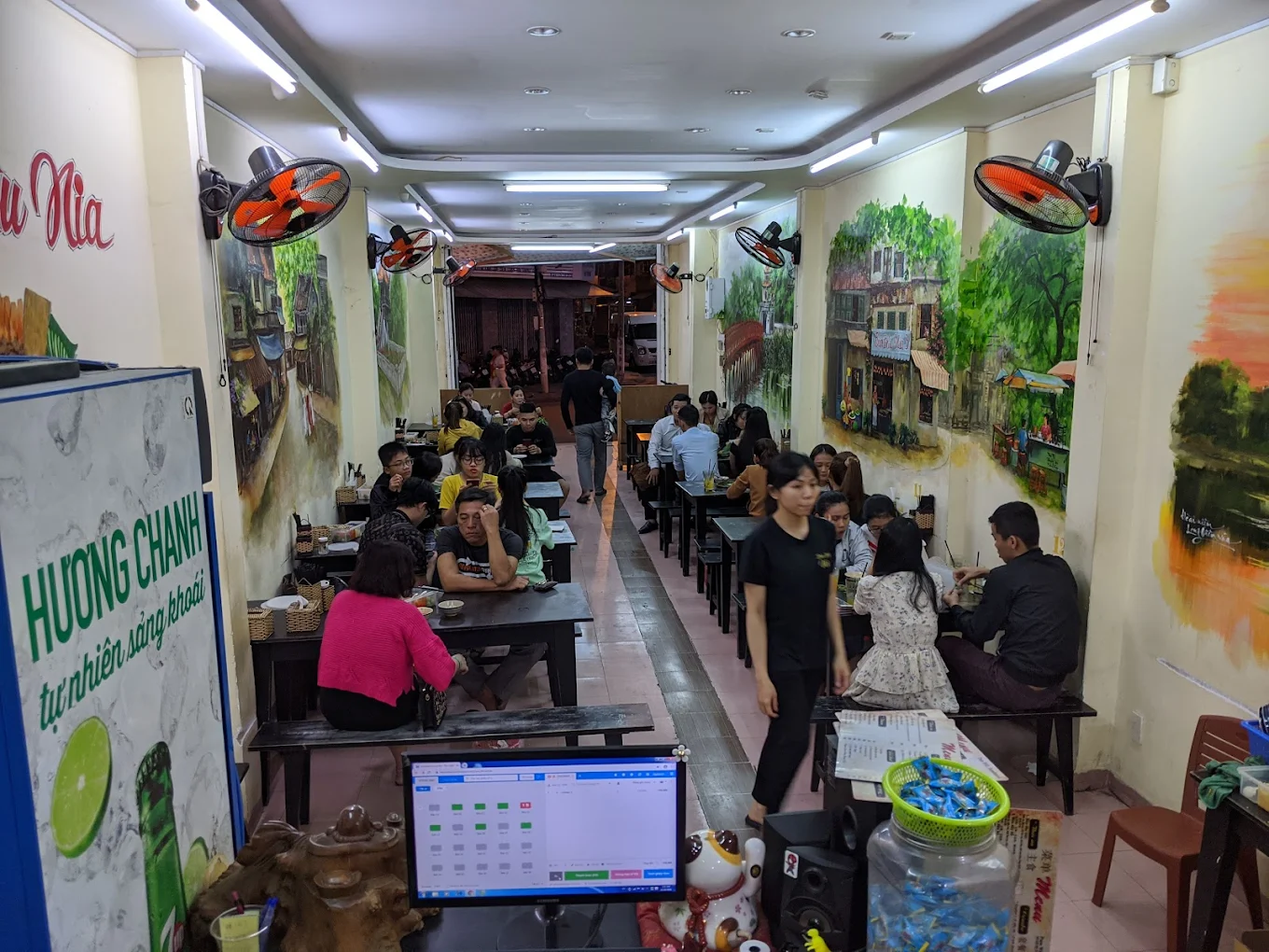 Không gian mộc mạc với bàn ghế gỗ truyền thống tại quán Nia