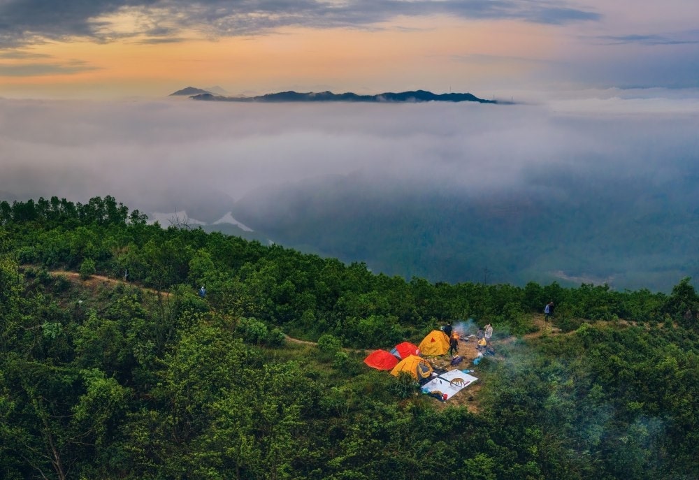 Biển mây trắng xóa ôm trọn đỉnh núi hoang sơ hùng vĩ.