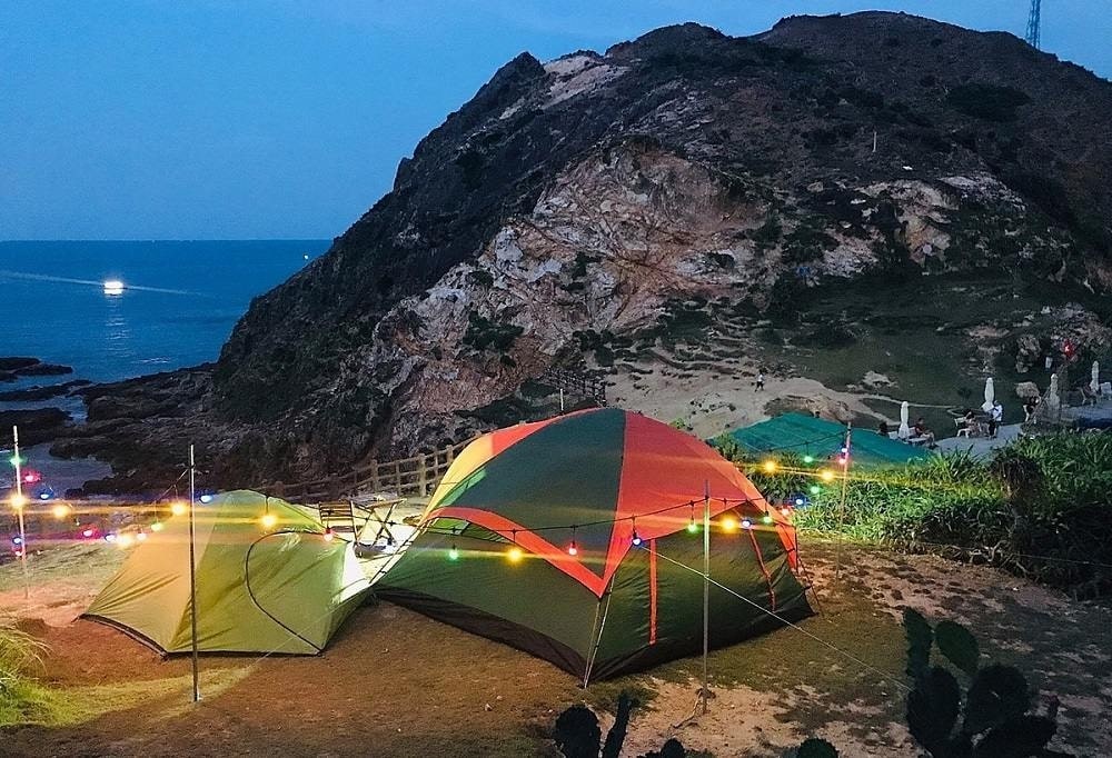 Lều trại dựng bên bờ biển, đón màn đêm dần buông