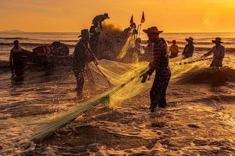 Ngư dân làng chài Nhơn Hải đang kéo lưới trên thuyền