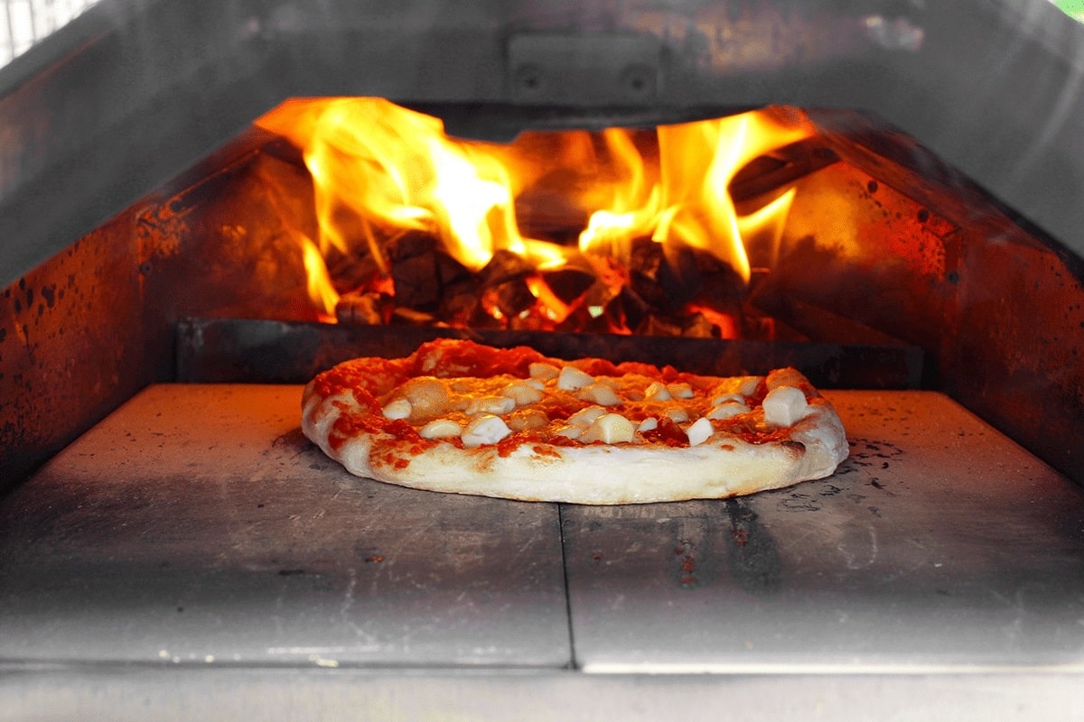 Pizza nướng trực tiếp trong lò củi