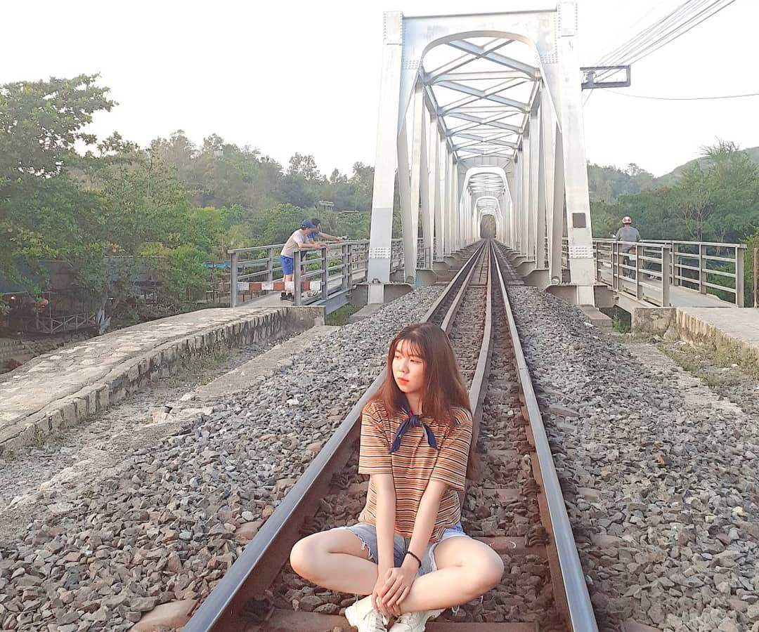 Du khách tạo dáng chụp ảnh với cầu sắt Nha Trang
