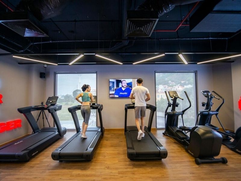 Phòng Gym với thiết bị tập luyện hiện đại và khu vực tạ tự do.