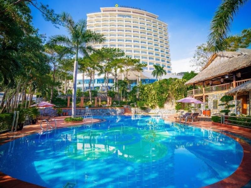 Hồ bơi ngoài trời với làn nước trong xanh, khu vực ghế nằm thư giãn và không gian thoáng đãng.