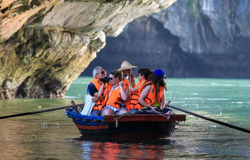 Du khách ngồi đò nam khám phá vịnh biển