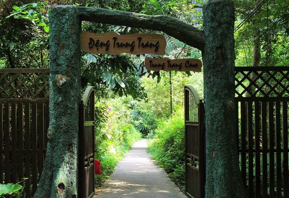 Lối vào Động Trung Trang có cây xanh mát và không khí trong lành